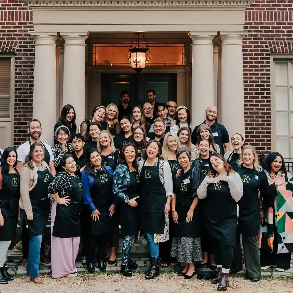 A large group of K Cateirng staff in front of the Denny Blaine mansion