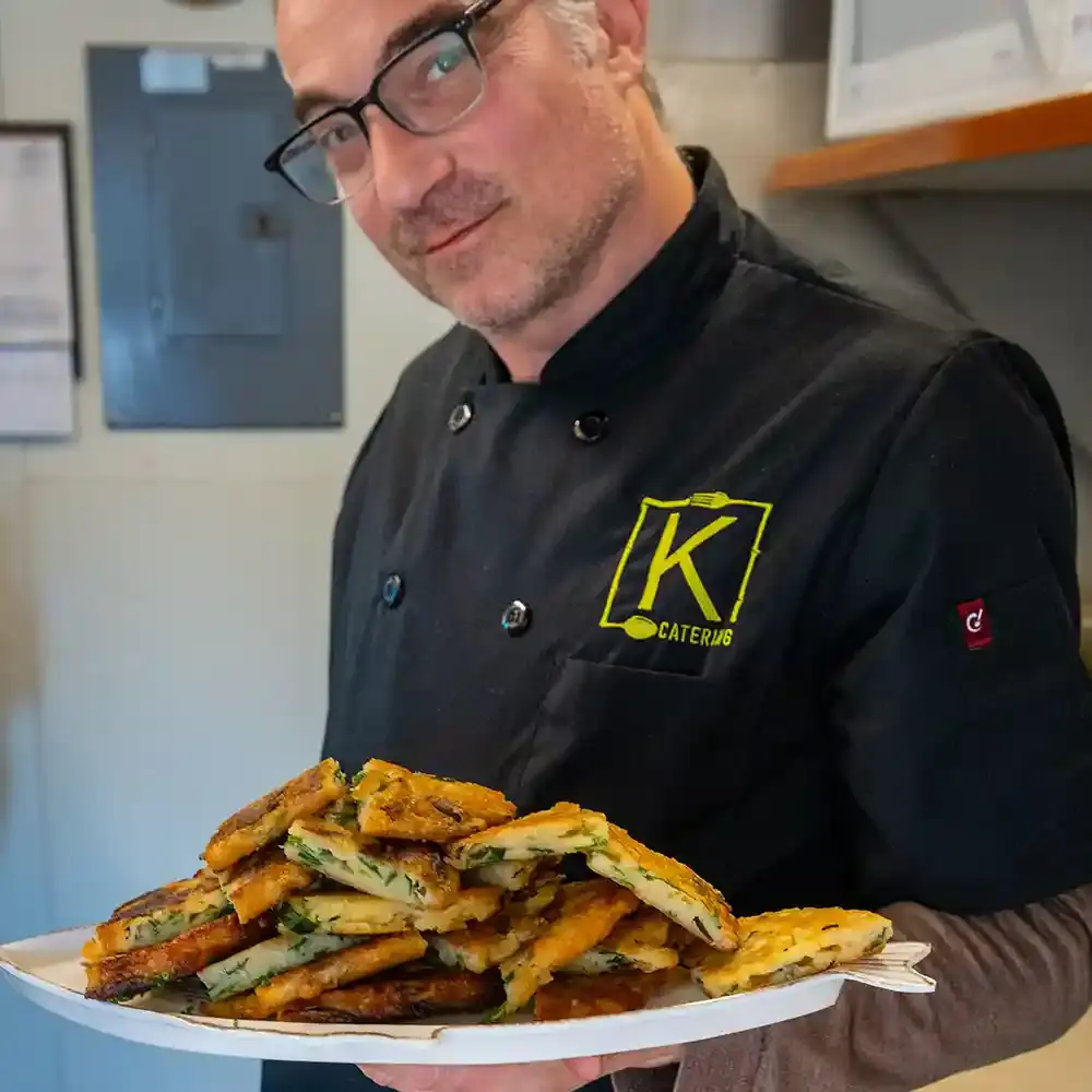 A K Catering chef with a plate of delicious chive pancakes